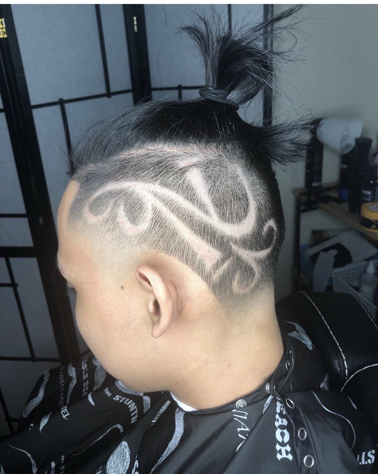 Freehand design shaved into a top knot haircut by Eiron Pascua