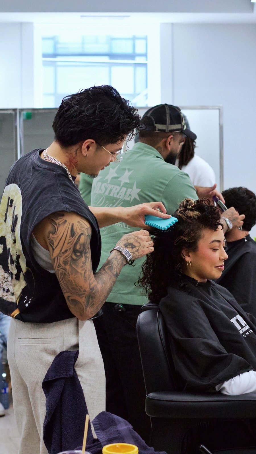 Stylist blow-drying a client's curly hair at fyf North